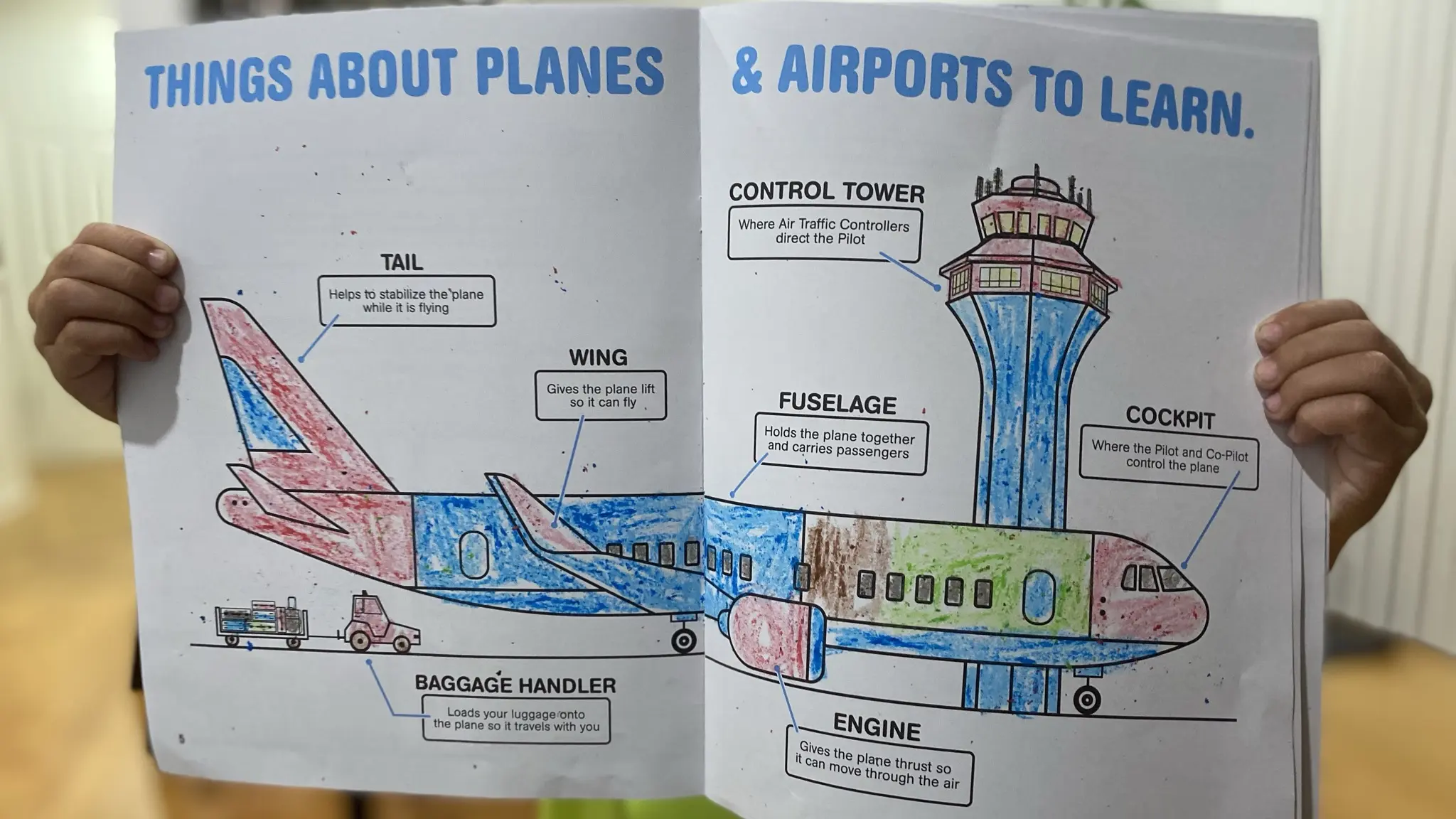 Child holding an illustrated Jr. Flight Crew activity book about planes and airports